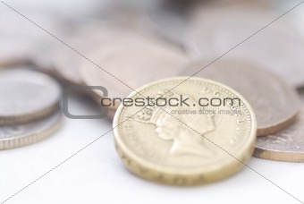 Spilled coins, focus on £1 coin.