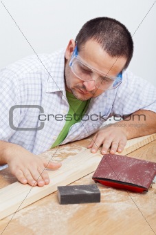 Man furbishing wooden planck