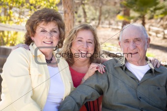 Portrait of Senior Couple with Daughter in the Park.
