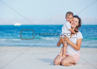 Young mother and her son playing at beach