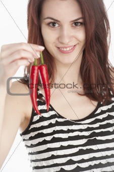Young woman holding two red chili peppers