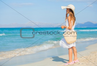 Adorable girl wearing elegant hat on the beach