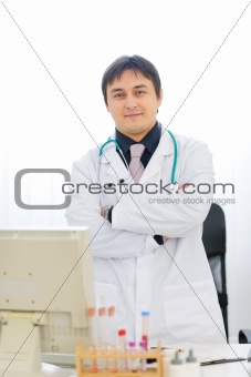 Portrait of medical doctor standing at table