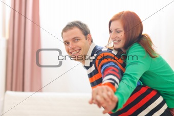 Smiling red hair young woman piggybacking boyfriend