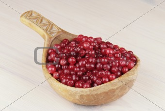 ripe cranberry in wooden bowl on the table