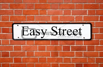 Easy street sign on a brick wall.