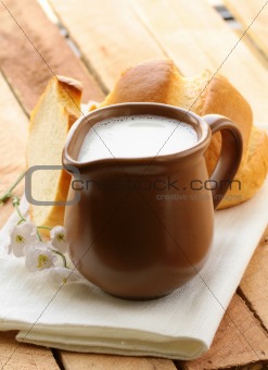 pitcher of milk on a wooden table, rustic still life