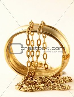gold jewelry, bracelets and chains on a white background