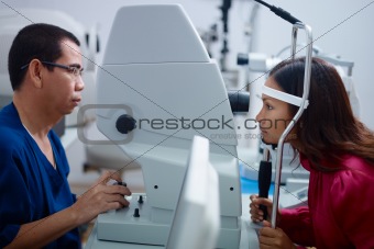 Eyesight exam in clinic with Asian doctor and female patient
