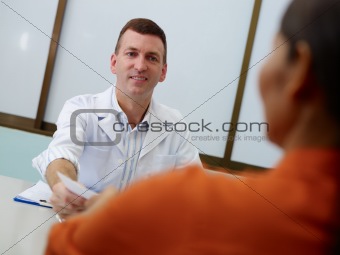 Gynecologist working and talking to woman in clinic