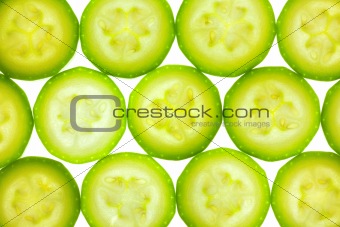 Slices of zucchini or courgette isolated on white / back lit