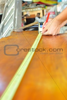 man working and measuring  wood