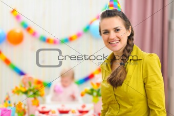 Portrait of mother and celebrating baby in background