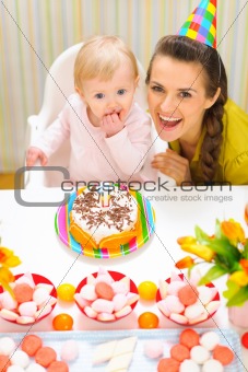 Portrait of happy mom and baby with birthday cake