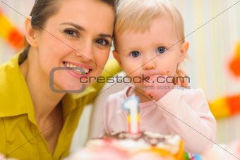 Portrait of mother and kid eating birthday cake