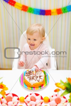 Happy eat smeared baby eating first birthday cake