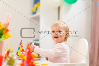 Portrait of eat smeared kid eating birthday cake