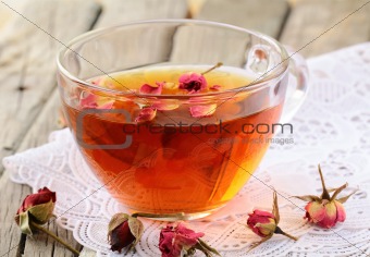 cup of tea with dried roses on a wooden table