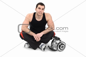 young man posing with dumbbell sitting on floor, on white background