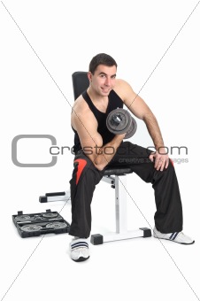 young man posing with dumbbell sitting on bench, on white background