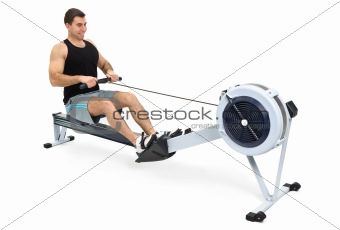 man doing exercises on rowing machine, on white background