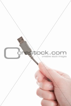 Hand holding grey USB cable 