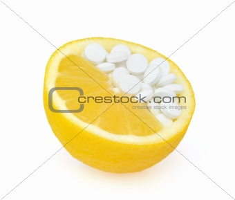 Close up of lemon and pills isolated - vitamin concept