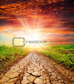 sunset over cracked rural road