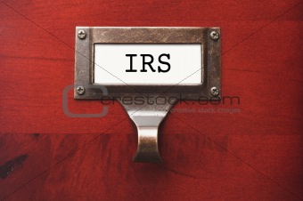 Lustrous Wooden Cabinet with I.R.S. File Label in Dramatic LIght.