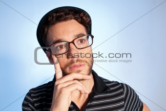 Young man modern nerd thinking wide angle portrait blue background