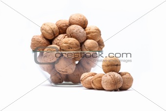 Walnuts are a lie in a glass bowl isolated on a white background