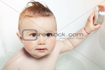 Cute baby exploring a bathtub