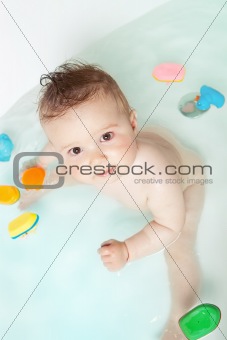 Cute baby looking up while taking a bath 