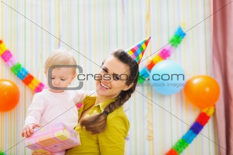Portrait of happy mom and baby with birthday gift