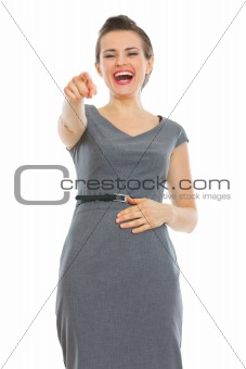 Portrait of laughing business woman pointing in camera
