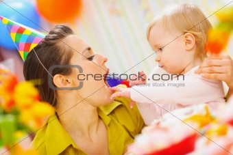 Baby feeding mother with birthday cake