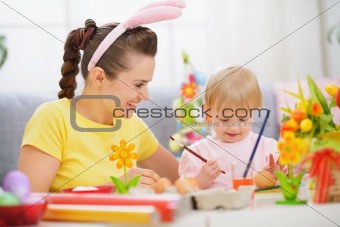 Mother and baby painting on Easter eggs