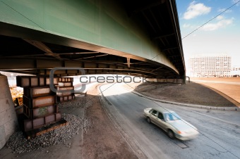 Blurred car moving under an old bridge