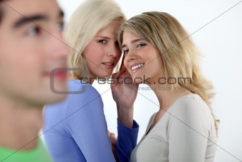 Young women gossiping about a man
