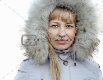 Portrait of young girl in a jacket with a fur hood