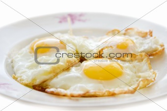 Three eggs on a plate isolated on white