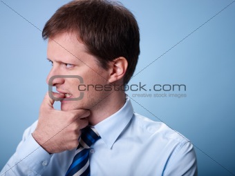 nervous business man biting finger nails 