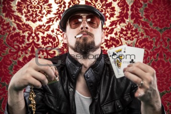 Gangster Looking Man Holding Poker Cards and His winnings