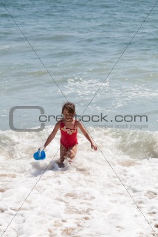 Little Girl Playing with a Bucket on the Beach