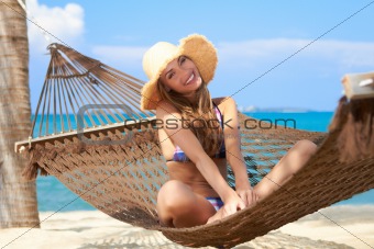 Woman with lovely smile sitting in a hammock