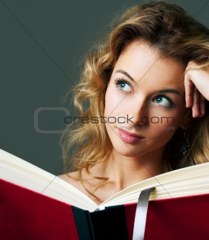 Woman holding book and dreaming. Copy space.