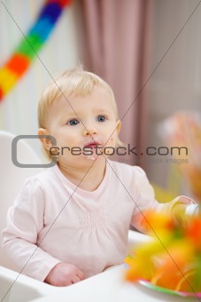 Portrait of thoughtful baby sitting at table