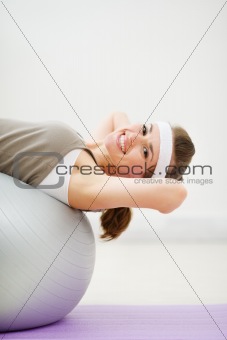 Happy woman doing abdominal crunch on fitness ball