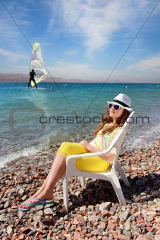 a young girl resting on the sea