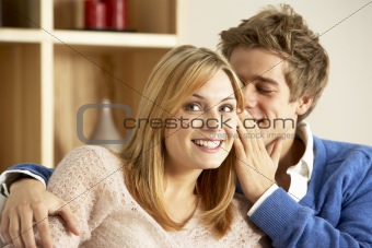 Young Couple Whispering To Each Other